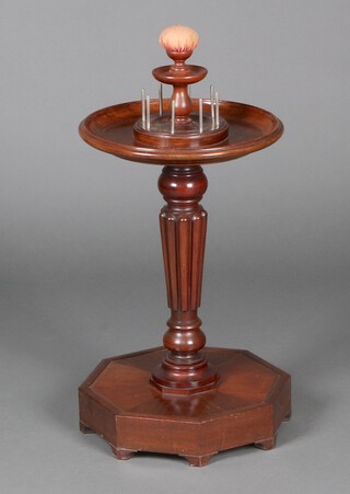 A circular turned mahogany dish top sewing/bobbin stand, raised on turned and fluted column with octagonal base 62cm h x 41cm diam. (made up), having a pin cushion to the top 