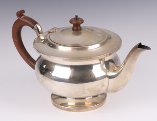 A circular silver teapot with beech handle Birmingham 1924 by Mappin & Webb, gross weight 468 grams 