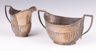 An Edwardian silver milk jug with demi-reeded decoration, together with a twin handled sugar bowl with engraved inscription, Sheffield 1905, 358 grams 
