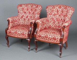 A pair of Edwardian tub back armchairs upholstered in red and white floral buttoned material, raised on cabriole supports 90cm h x 70cm w x 52cm d 