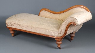 A Victorian carved oak show frame chaise longue upholstered in yellow material, raised on turned and reeded  supports 75cm h x 185 cm w x 62cm d 