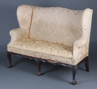 An Edwardian Georgian style high backed winged 3 seat sofa, upholstered in gold floral patterned material, raised on cabriole ball and claw supports, 116cm h x 153cm w x 62cm d  