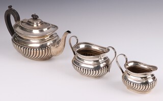 A Victorian 3 piece bachelor's tea service with demi-reeded decoration London 1897, maker Samual Walton Smith, the teapot with ebonised handle and finial, gross weight 798 grams  