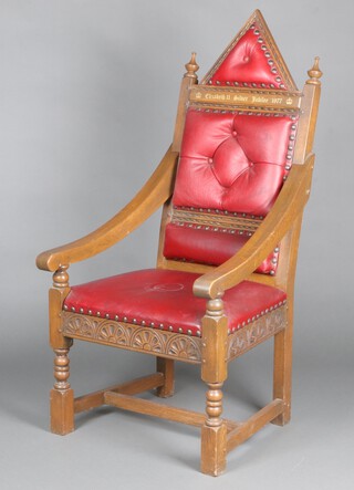 A 1977 Queens Silver Jubilee oak framed throne chair, the base numbered 22, upholstered in red material and raised on turned and block supports 140cm h x 67cm w x 64cm d 
