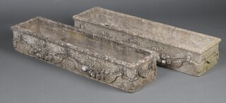 A pair of well weathered rectangular concrete garden planters decorated with fruit and lion masks 21cm h x 119cm w x 31cm d 
