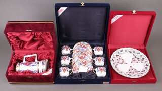 A Gural porcelain tankard, a 12 piece coffee service of 6 cups and 6 saucers and a circular plate all contained in a plush lined boxes