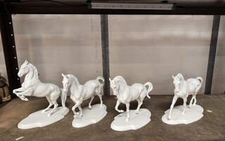 Four white bisque figures of horses depicting dressage movements  