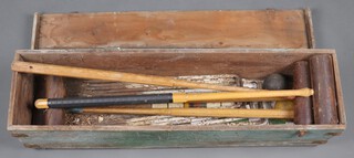 A croquet set comprising 4 mallets, 4 balls, 6 hoops and 2 pegs contained in a wooden box (hinge to box damaged) 