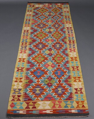 A yellow, brown and green ground Chobi Kilim runner with overall geometric designs 251cm x 79cm 