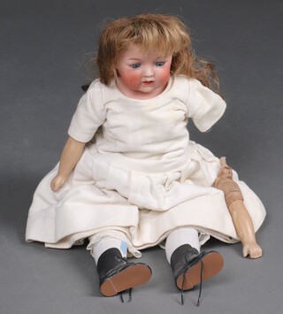A German bisque head doll with stuffed body and composition arms and legs with blue opening eyes, 52cm