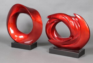 A pair of Barbara Hepworth style red plastic circular sculptures, on square bases 51cm h x 25cm x 16cm 