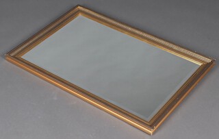 A rectangular bevelled plate wall mirror contained in a decorative gilt frame 63cm x 93cm 