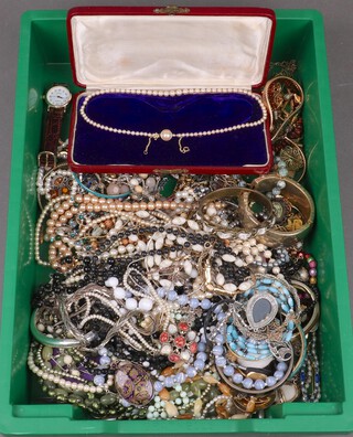 A string of simulated pearls contained in a plush case together with a collection of costume jewellery including bangles and beads 