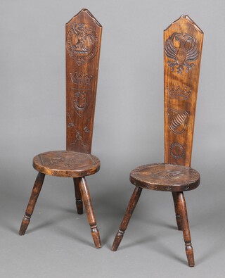 A pair of carved pine welsh spinning chairs one decorated a dragon, the other a rampant lion, raised on turned supports 100cm