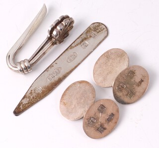A pair of silver oval cufflinks London 1988, a silver napkin clamp in the form of a shell with millennium hallmark and a silver collar stiffener, 26g