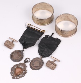 A pair of barked silver cufflinks, 3 silver watch chain medallions and 2 silver napkin rings 73 grams gross 