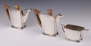 An Art Deco 3 piece silver coffee service of rectangular form comprising coffee pot, hot water jug and twin handled sugar bowl, Sheffield 1938, maker Stower and Wragg Ltd, the coffee pot and hot water jug with wooden handles and finials, 1566 grams gross