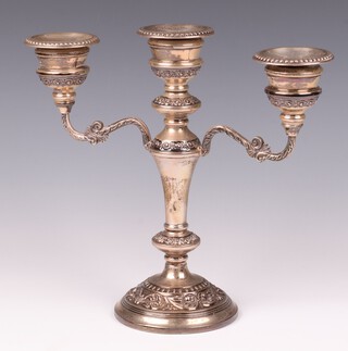 An embossed silver 3 light candelabrum raised on a circular weighted base, with detachable sconces  Birmingham 1962, by W I Broadway & Company 23cm 