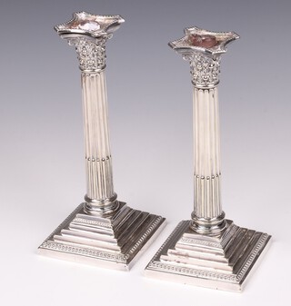 A pair of stepped silver plated reeded candlesticks with Corinthian column capitals 24cm 