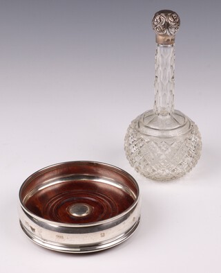 A club shaped cut glass scent bottle with embossed silver lid 18cm, marks rubbed, together with a 925 standard silver bottle coaster with millennium hallmark 12cm 