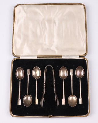 A set of 6 silver coffee spoons Birmingham 1931 by I S Greenberg & Co., together with a pair of non matching sugar tongs, 64 grams, contained in an associated case 