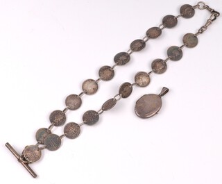 An Albert chain formed from Victorian 2 annas coins, together with a silver locket pendant and a silver napkin ring 