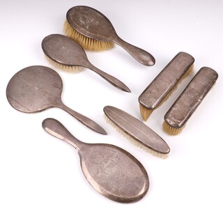 A 4 piece silver backed dressing table set comprising hand mirror, hair brush and pair of clothes brushes London 1905 and 1906, and a 3 piece ditto with hand mirror, hair brush and clothes brush Birmingham 1966