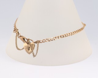 A 9ct yellow gold curb link bracelet with heart shaped padlock, 18cm, 3.9 grams 