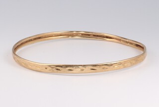A yellow gold, testing as 9ct hollow bangle (some dents), 4.6 grams