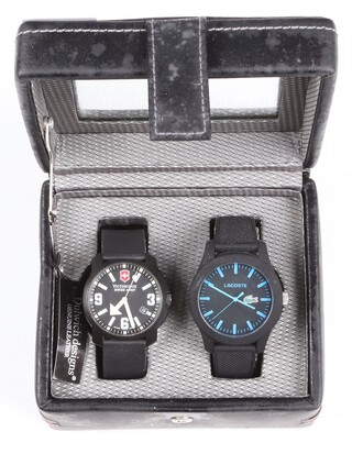 A Victorinox Swiss Army watch together with a Lacoste fashion watch, both within a display box 