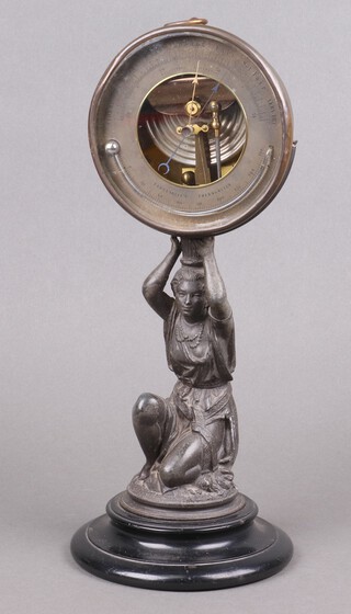 An aneroid barometer, the 12cm silvered dial contained in a gilt metal case, raised on an associated base supported by a spelter figure of a kneeling lady, the reverse marked PHBN  