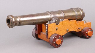 A reproduction Victorian model canon with 43cm barrel, raised on a wooden gun carriage