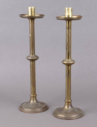 A pair of ecclesiastical brass candlesticks with drip trays, raised on circular bases 39cm x 11cm 
