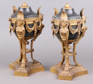 A pair of gilt ormolu and black metal urns and covers supported by females busts, raised on triform bases, 34cm h x 14cm, converted for use as table lamps 