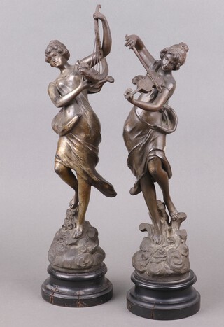 A pair of Victorian spelter figures of standing lady violinist and harpist, raised on socle bases 30cm