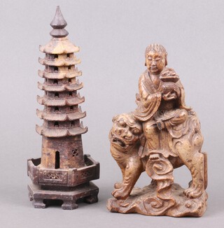 A 19th Century Chinese carved soapstone figure of a man sitting on a Dog of Fo with basket 20cm h x 11cm w x 5cm d, together with a carved pierced hexagonal soapstone pagoda 24cm 