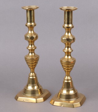 A pair of 19th Century polished brass candlesticks with knopped stems and ejectors, stamped Solid English 30cm 