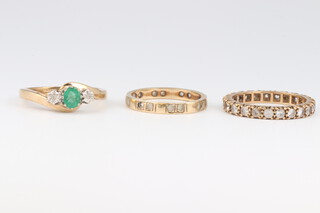 A 9ct yellow gold dress ring set an oval emerald approx. 0.4ct, supported by 2 diamonds, size M 1/2 2.52 grams together with 2 paste set eternity rings sizes L and N 1/2  