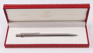 A Cartier Must De Cartier ballpoint pen, cased and with original guarantee and instructions 