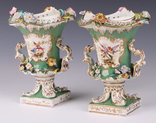 A pair of 19th Century Derby style green and gilt twin handled vases with panel decoration of birds, on square bases 21cm 