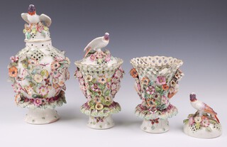 A pair of 18th Century Derby frill vases and clovers, floral encrusted with ribbon ware tops, the bodies with twin face masks, heavily encrusted with flower heads and decorated butterflies 16cm, the pierced porcelain lids with bird finials, together with a similar urn and cover 31cm 