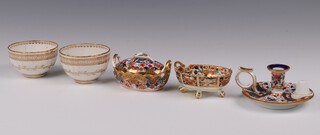 Two 18th Century Derby white and gilt glazed tea bowls 5cm (both cracked), a Derby Imari pattern chamber stick 8cm (handle cracked missing snuffer), an oval Derby twin handled bowl 8cm (missing 1 handle) and a Spode oval Imari pattern pot pourri and cover 967 7cm 