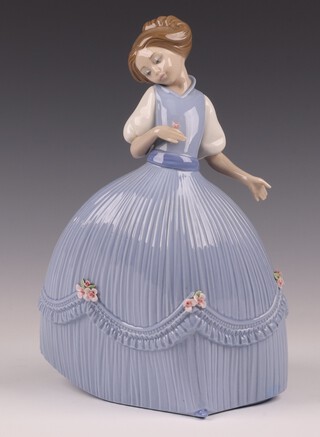 A Lladro figure of a standing lady holding a rose, the base marked 10M, 24cm 