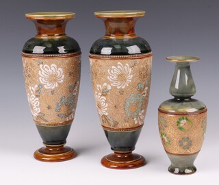 A pair of Doulton Lambeth green and brown salt glazed vases with floral decoration, base impressed 9386, 29cm and a similar salt glazed vase 97672 21cm 