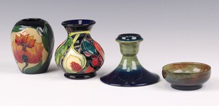 William Moorcroft, a circular green glazed bowl without decoration the base impressed Moorcroft 2cm, a similar stub shaped candlestick 6cm (chip to base), a Queens Choice 2000 Moorcroft vase decorated fruit 9cm (crazing to base) and 1 other marked 2005 decorated flowers 9cm 