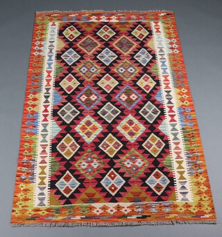 A black, tan, green and orange ground Maimana Kilim rug with all over geometric design  188cm x 122cm