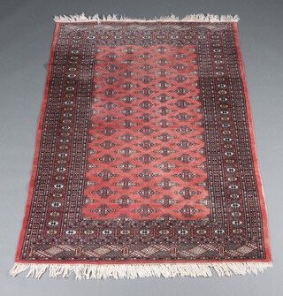A pink and grey ground Bokhara rug with 60 medallions to the centre 183cm x 128cm 