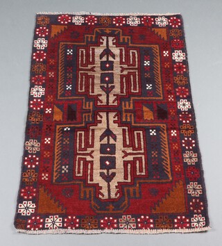 A black, brown and white ground Belouche rug with 2 stylised medallions to the centre 131cm x 88cm 