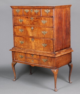 A Queen Anne oak lined crossbanded walnut chest on stand with moulded cornice, fitted 3 short drawers above 3 long drawers, the base with 1 long drawer, raised on later cabriole supports 152cm h x 103cm w x 56cm d 