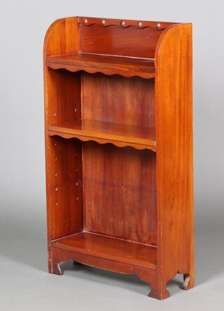 An Art Nouveau Liberty style mahogany bookcase with raised back, carved roundel and arch shaped sides 106cm h x 61cm w x 21cm d 